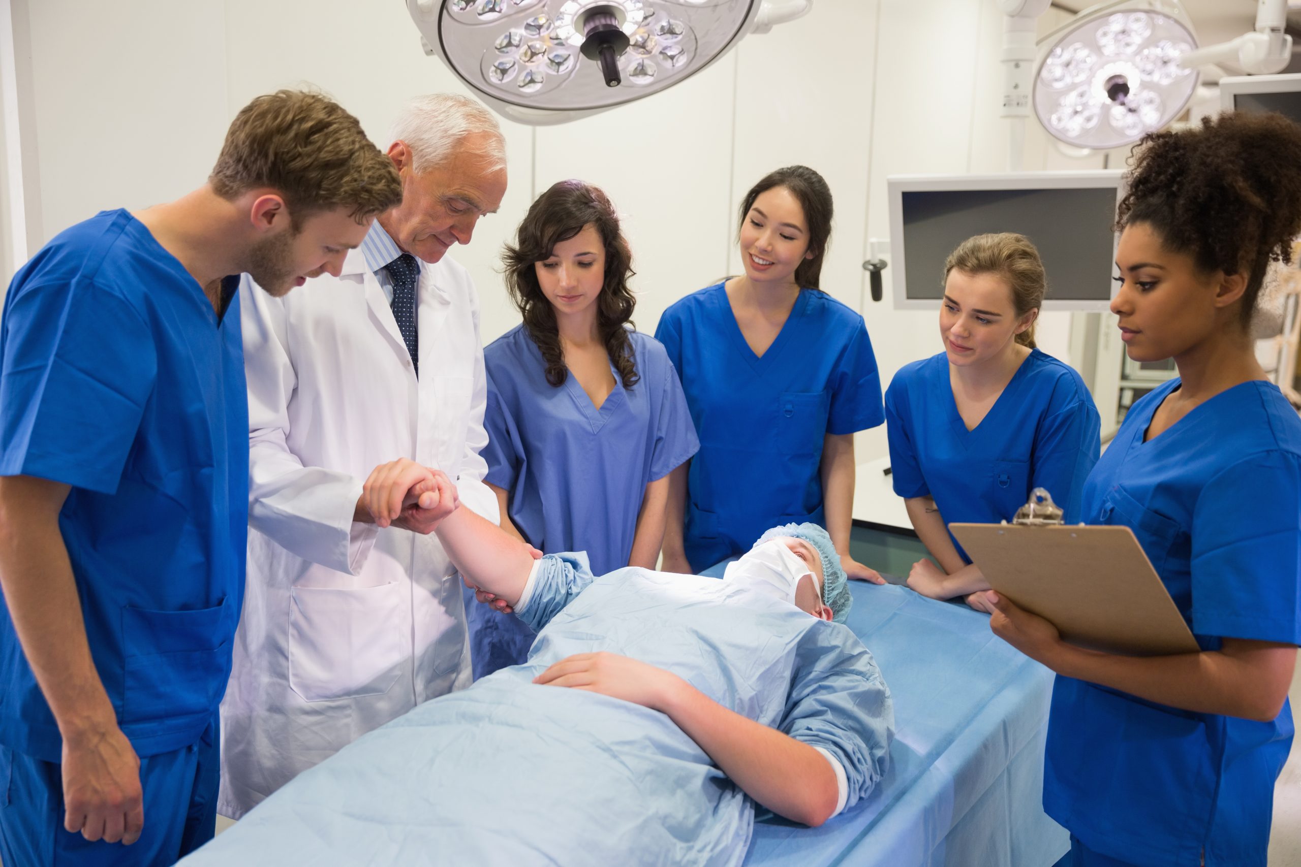 Operating theatre staff gather around a patient